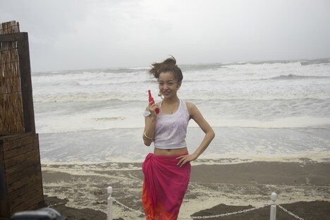 大荒れの由比ケ浜をバックに笑顔の板野友美。(写真提供:キングレコード)