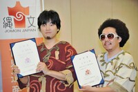 任命書を掲げる秦と池田。