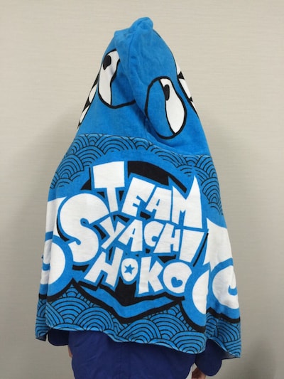 新グッズ「フード付タオル」にくるまった咲良菜緒。