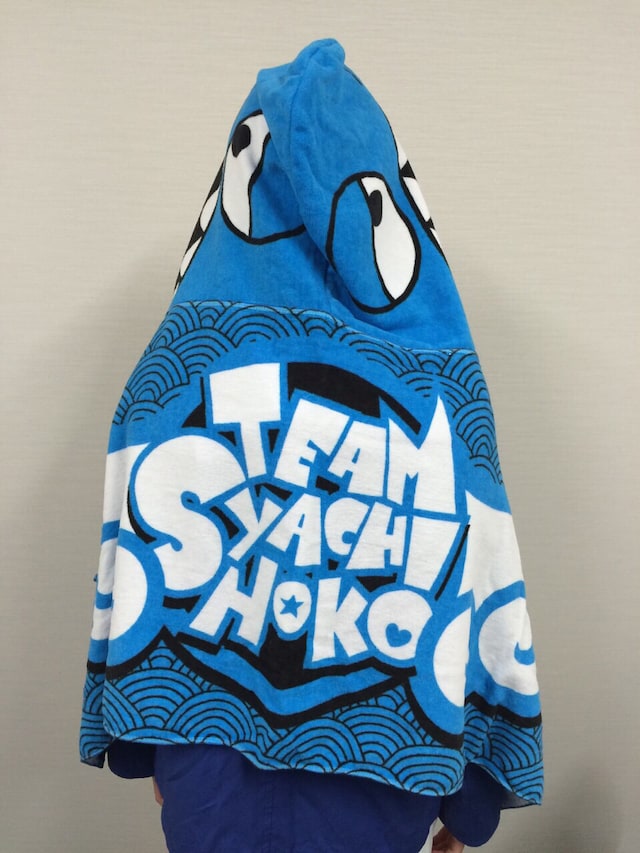 新グッズ「フード付タオル」にくるまった咲良菜緒。