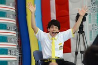 挙手をするユースケ。