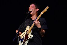 ギターを弾く高橋茂雄（サバンナ）。