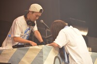 ヘッズと記念撮影するため用意していた自撮り棒が使えないトラブルにみまわれる岩渕竜也（左）とhina（右）。