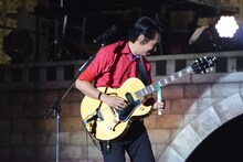 ネギライトを使い、ボトルネック奏法の要領で演奏する田島貴男。