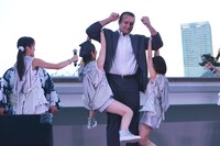 腕に軽々とメンバー2人をぶら下げる鳴戸親方。