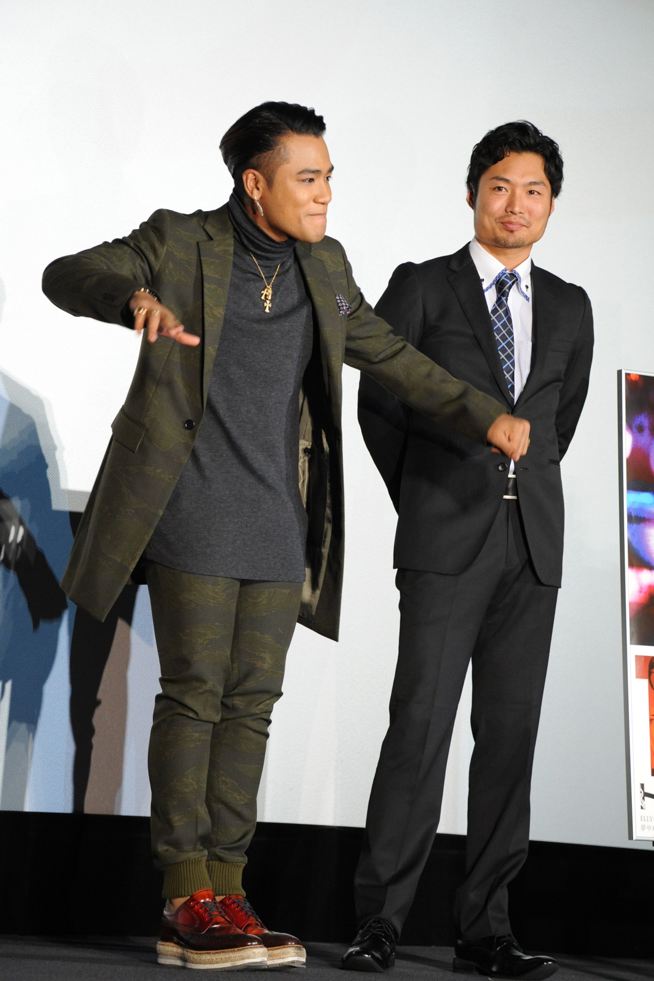 左から、写真撮影時にダンスを踊ってみせたELLYと、彼を見る八木将康。