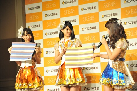 キャンペーンでプレゼントされるランチョンマットの説明をする柴田阿弥。