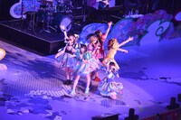 世界地図が描かれたステージの上で歌うでんぱ組.inc。