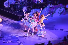 世界地図が描かれたステージの上で歌うでんぱ組.inc。