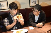 食レポに挑戦するユースケ（左）を見守る鈴木拓（右）。