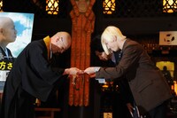 「Today, Tonight」の歌詞が書かれた紙を寺務長に手渡す山田義孝（Vo）。