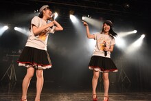 lyrical schoolのTシャツとキャップを身に付けて上機嫌の高橋麻里、白戸佳奈。