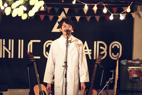 白衣姿の岡田一成（Dr）（撮影：後藤壮太郎）