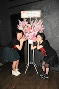 凱旋公演記念の花の前で記念撮影する藤田あかり、野田怜奈。