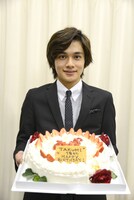 終演後、ケーキを手に笑顔を浮かべるTAKUMI。