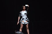 会場中央から現れ、ステージにスマホを向けるのっち。