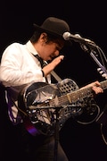 ドブロギターをパーカッションのように叩いて演奏する田島貴男。