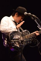 ドブロギターをパーカッションのように叩いて演奏する田島貴男。