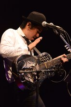 ドブロギターをパーカッションのように叩いて演奏する田島貴男。