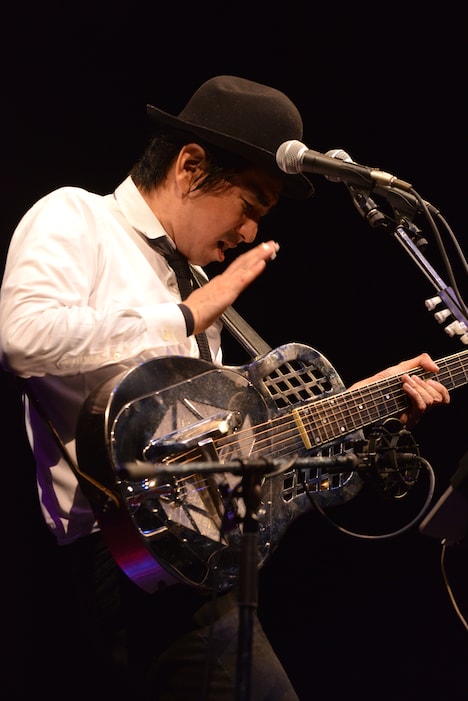 ドブロギターをパーカッションのように叩いて演奏する田島貴男。