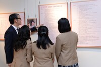 会場内を案内する嶺脇社長（左端）。