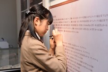 展示物の誤字を見つけ、訂正する大賀咲希。