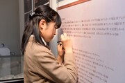 展示物の誤字を見つけ、訂正する大賀咲希。