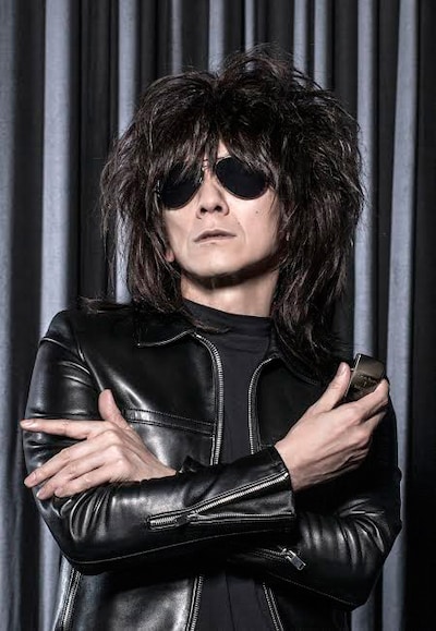 自らが監修したオリジナルZippoライターを手にする吉井和哉。