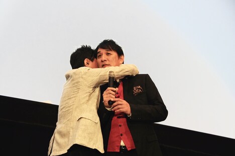 舞台挨拶中にピエール瀧(右)に抱きつく石野卓球(左)。