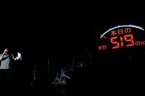 司会兼レフェリー役の星野卓也がこの日の合計デシベル数を発表する様子。 （撮影：洲脇理恵［MAXPHOTO］）