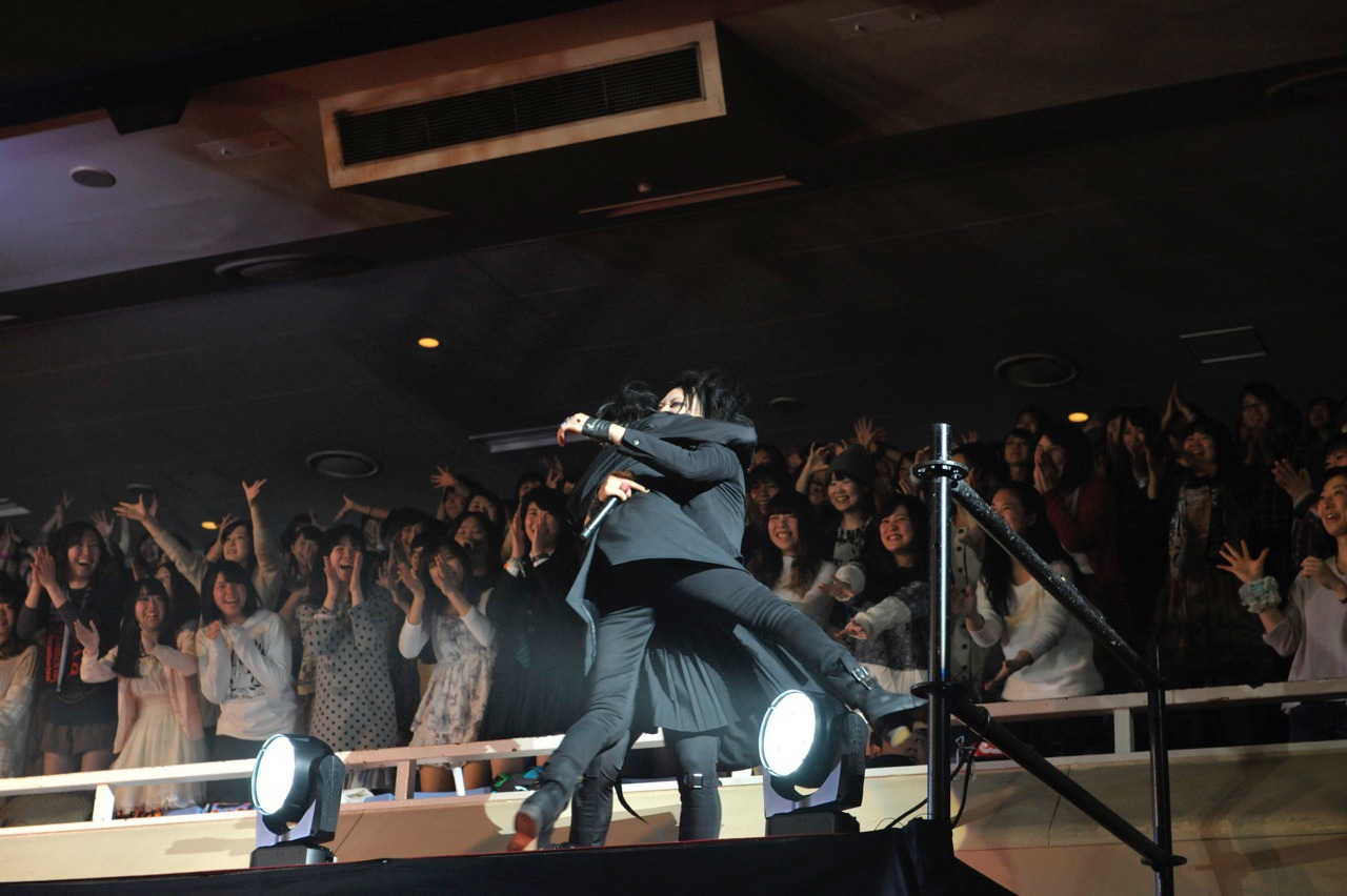 マオ（Vo / シド）を抱き上げる逹瑯（Vo / MUCC）。