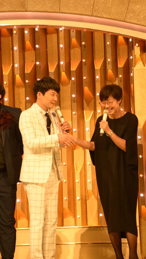 握手を交わす星野源（左）と総合司会の有働由美子アナウンサー（右）。