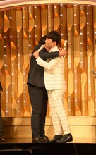 歌唱前に日村勇紀（バナナマン / 左）と抱擁を交わす星野源（右）。