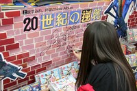 東京・とらのあな秋葉原店Bの「20世紀の逆襲」特設コーナーにサインする上坂すみれ。
