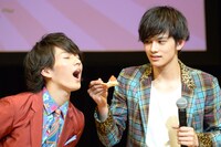 “あーん”を待つMASAKI（左）を横目で見るTAKUMI（右）。