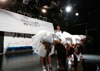 深々と頭を下げるロッカジャポニカの背後にサプライズ発表を仕込むスタッフ。（撮影：笹森健一）