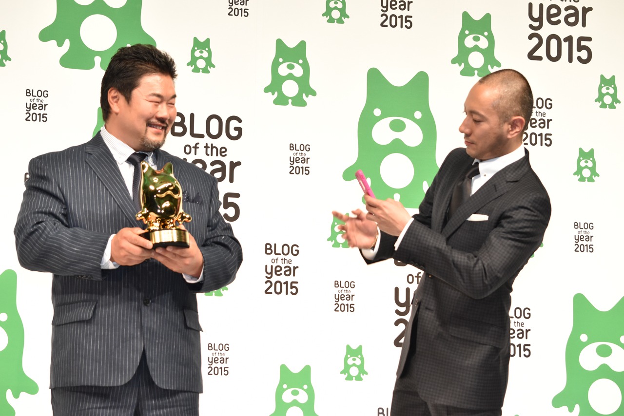 自身のブログ用に佐々木健介（左）の写真を撮影する市川海老蔵（右）。