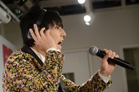 大声を出さないように、マイクを遠ざけて話すユースケ。