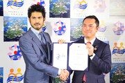 握手する平井堅と鈴木英敬知事。