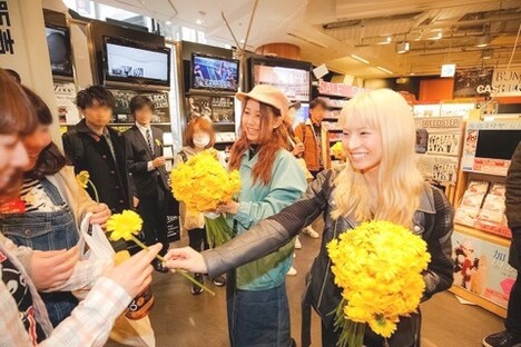 ファンに花をプレゼントするTOMOMIとHARUNA。(写真提供:EPICレコードジャパン)