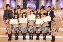左から倉本美津留、2015年度さくら学院、担任の森ハヤシ。（写真提供：アミューズ）