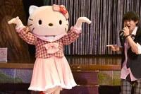 “九官鳥”のポーズを決めるハローキティ（左）と佐野勇斗（右）。(c)2016 SANRIO CO., LTD.