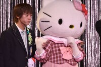 ハローキティ（右）と手をつなぐ山崎悠稀（左）。(c)2016 SANRIO CO., LTD.