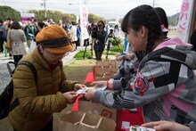 宗像市親善大使の名刺を配る西垣有彩。（撮影：上山陽介）