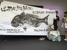 「ばってん少女鯛（隊）」にサインを書き入れる希山愛。（写真提供：ビクターエンタテインメント）