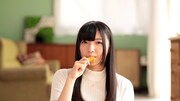 「おむすび名人」のWeb CMのワンシーン。おむすび名人をほおばる永野愛理。
