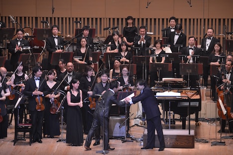 握手を交わす作曲家・酒井健治と指揮者・山下一史(写真中央)。