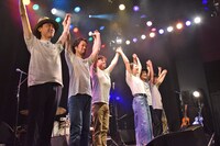 バンドメンバーと手をつないで挨拶する加藤いづみ。