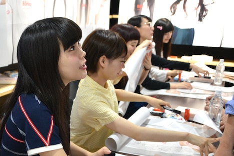 ポスターにサインをするBiSH。