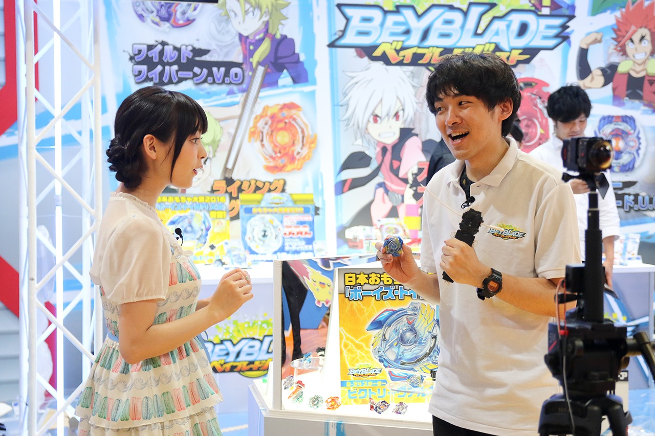 タカラトミーのスタッフにベイブレードのレクチャーを受ける上坂すみれ。